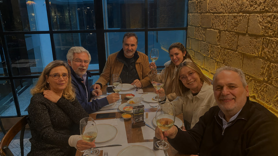 Grupo de personas compartiendo una mesa y brindando en el ambiente cálido de Renne.